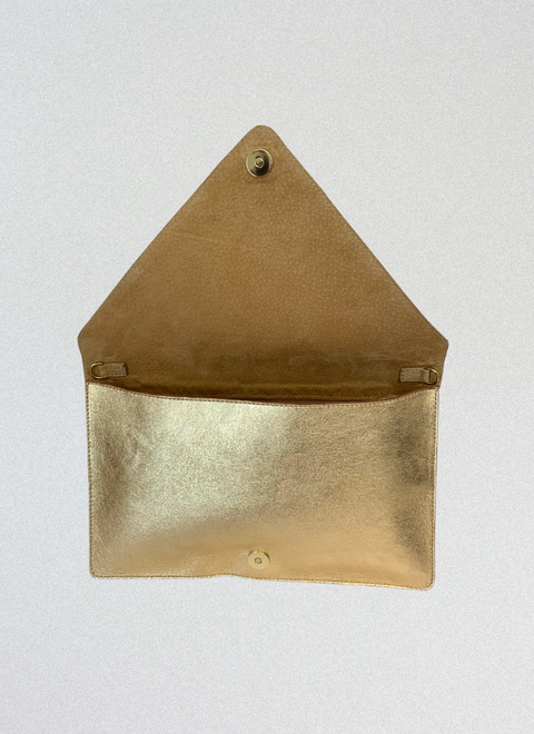 Bolso clutch dorado abierto mostrando su interior de piel, ideal para llevar móvil, llaves y esenciales.