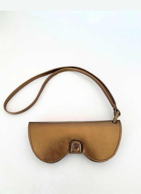 Funda de gafas en piel metalizada color bronce con su correa para colgar. Elegancia moderna y protección suave para tus lentes.
