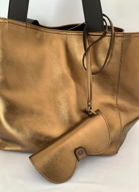 Set de bolso dorado y funda de gafas a juego. Diseño exclusivo en piel metalizada para un look de verano brillante.