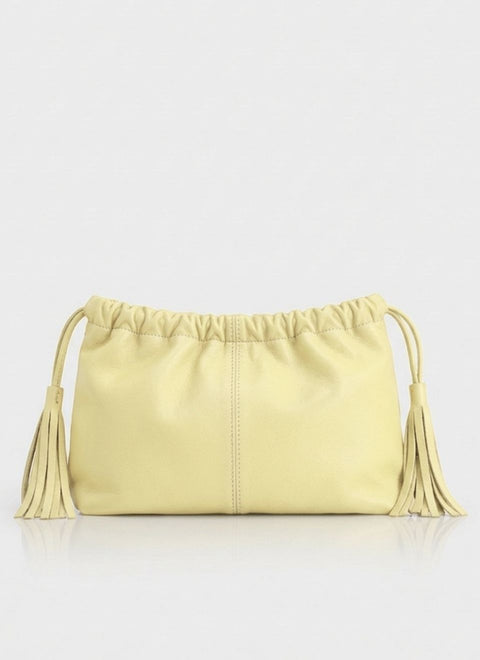 Bolso amarillo pastel de mano o clutch en piel, con adorno de ceñido en la parte superior y con tiras de pel terminadas con flecos a los laterales