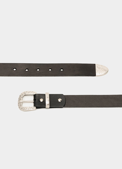 Cinturón de piel negra unisex extendido. Hebilla plateada con textura martillada y diseño sobrio, ideal para jeans o looks casuales.
