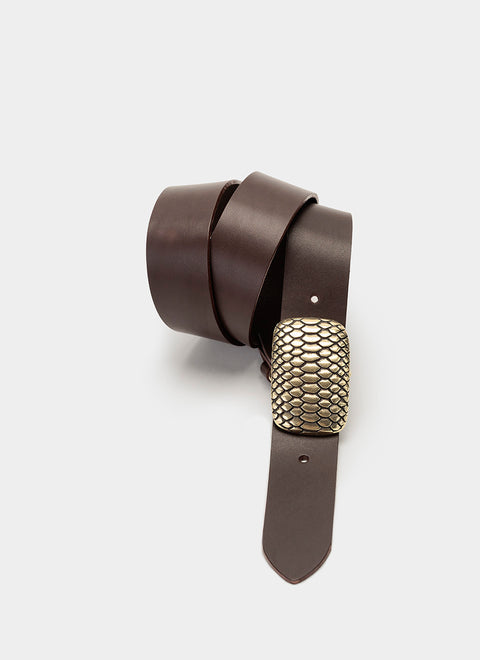Cinturón de cuero marrón oscuro para hombre, enrollado con hebilla dorada envejecida de textura tipo piel de serpiente. Elegancia refinada hecha a mano en cuero de curtido vegetal.