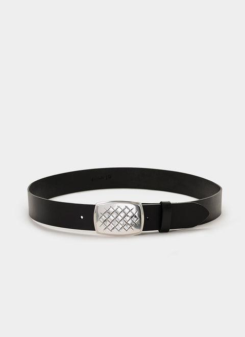 Detalle de hebilla plateada con patrón de rejilla de diamante y forma curva, hecha en zamak. Estilo moderno y sofisticado con acabado arquitectónico.