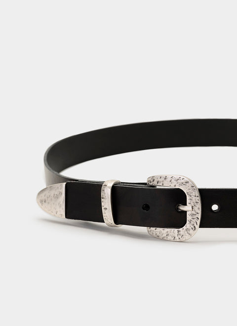 Detalle de la hebilla redondeada, pasador y puntera en tono plateado claro con acabado martillado. Estilo western sutil con textura elegante y resistente.