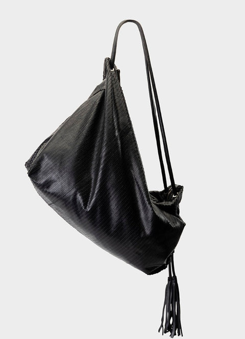 bolso de piel troquelada en negro. flexible y con flecos al final del asa