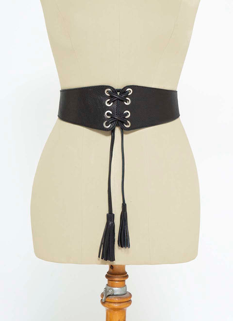 Cinturón ancho tipo corset en piel negra. Tiene dos tiras con borlas